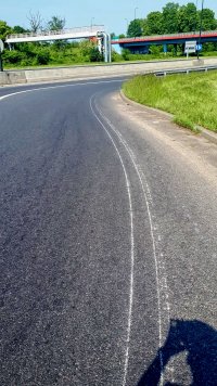 Widoczne żłobienie warstwy asfaltu charakterystyczne do ciągnięcia ciężkiego przedmiotu