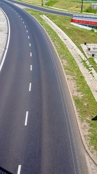 Widoczne żłobienie warstwy asfaltu charakterystyczne do ciągnięcia ciężkiego przedmiotu