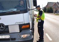 Policjant drogówki kontroluje kierowcę ciężarówki