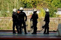 Policjanci w kaskach z tarczami na stacji kolejowej
