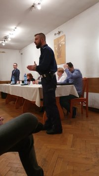 Policjant prowadzi prelekcję w sali pełnej ludzi.