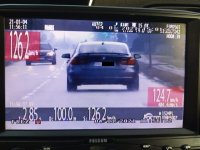 Widok ekranu wideorejestratora policyjnego, na ekranie samochód, który przekroczył prędkość.