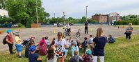 Policjanci na rowerach, dzieci słuchają wykładu.