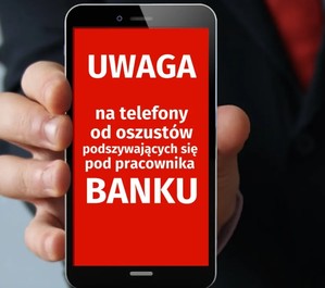 Na zdjęciu telefon z napisem na ekranie uwaga na oszustwo bankowe.