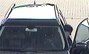 Na zdjęciu mężczyzna w czapce wychodzący z auta.